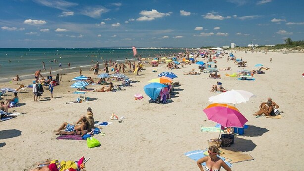 A crowded beach with people sunbathing and swimming, umbrellas, and beach chairs. - Air-conditioned apartment in city center - 2 guests (La Grande-Motte)