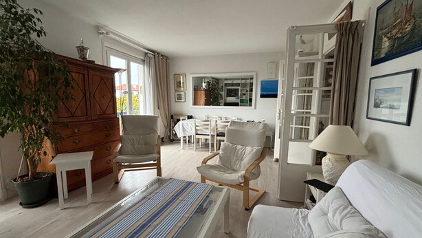 Una habitación con una cama, una silla, una mesa, una lámpara y una estantería.