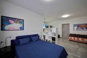 A bedroom with a bed, a nightstand, a bookshelf, and a sofa. - The Yellow Roses: Family Room (Mandello del Lario)