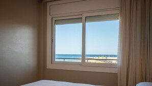 Una habitación con cama, ventana vista al mar y cortina.