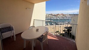 A balcony with a table and chairs, a view of a marina, and a tiled floor. - Apartment with parking - 4/6 guests (Port Leucate)