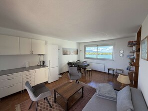 Un espacio habitable compacto con kitchenette, comedor y sofá.
