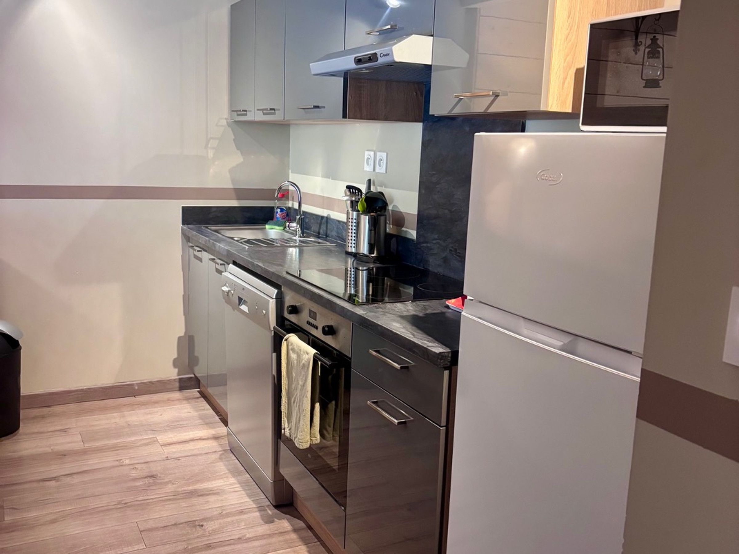 A modern kitchen with stainless steel appliances, a dishwasher, and a built-in oven.