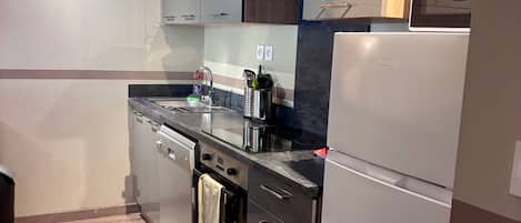 A modern kitchen with stainless steel appliances, a dishwasher, and a built-in oven.