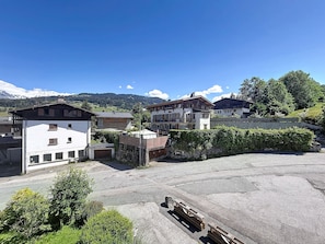 A residential area with houses, a paved parking area, and a mountainous backdrop. - Charming apartment in Combloux center - 4 guests (Combloux)