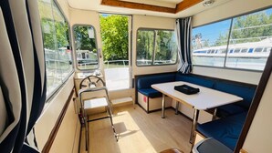 Un intérieur compact comprenant une table à manger, des sièges, un volant et des fenêtres.