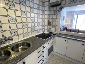 A kitchen with white cabinets, a double sink, a stove, and a window with a view of the outside. - Quiet apartment with balcony in the heart of Marbella (Marbella)