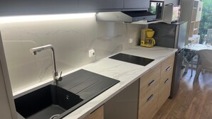 Een moderne keuken met een dubbele spoelbak, een koffiezetapparaat en uitzicht op de omgeving.