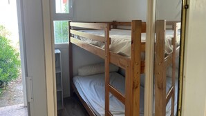 Een stapelbed met een raam, een deur en een klein bureau.