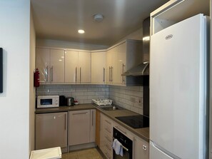 A compact kitchen with a microwave, toaster, and stainless steel appliances. - Parnell District Apartments (Dublin)