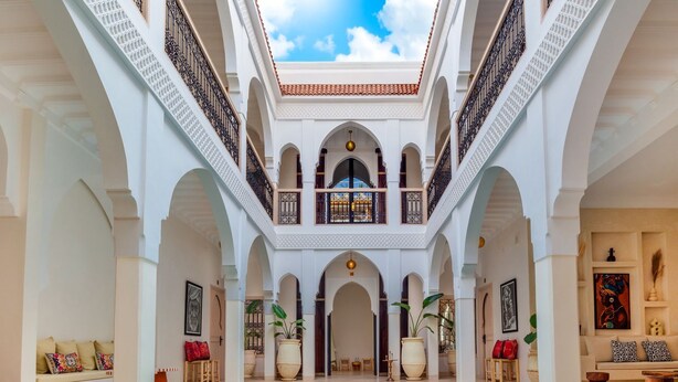 A luxurious indoor pool area with multiple arches, a central pool, and a high ceiling with a skylight. - Riad Dar Noa Marrakech (Marrakech)
