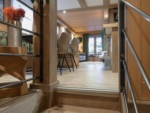 Eine Holztreppe führt zu einem Essbereich mit Stühlen und einem Tisch.