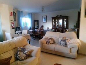 A living room with two sofas, a dining table, and a cabinet. - Comfortable house with AC - 10 guests (Granada)