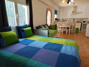 A bedroom with a bed, a desk, a chair, and a kitchenette. - Comfortable house with AC - 10 guests (Granada)
