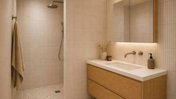 Une salle de bain moderne équipée d’une douche, d’un meuble-lavabo avec miroir et d’un porte-serviettes.