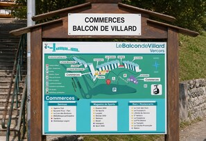 A sign for 'COMMERCES BALCON DE VILLARD' with a map and lists of services, sports shops, and bars/restaurants. - Apartment 'L'instant Vercors, Balcon Des Cimes' with Mountain View, Balcony and Wi-Fi (Villard-de-Lans)
