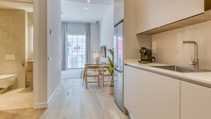 Une cuisine moderne dotée d’un évier encastré, d’une machine à café et d’un coin repas avec une table et des chaises.