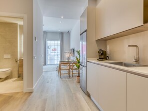 Eine moderne Küche mit Spüle, einer Kaffeemaschine und einem Essbereich mit Tisch und Stühlen.
