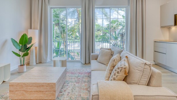 A modern living room with a sofa, coffee table, and a view of a balcony with plants. - Modern apartment near the port - 4 guests (Estepona)
