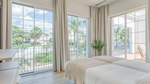 A bedroom with a large window, a bed, a bedside table, and a view of the outdoors. - Modern apartment near the port - 4 guests (Estepona)