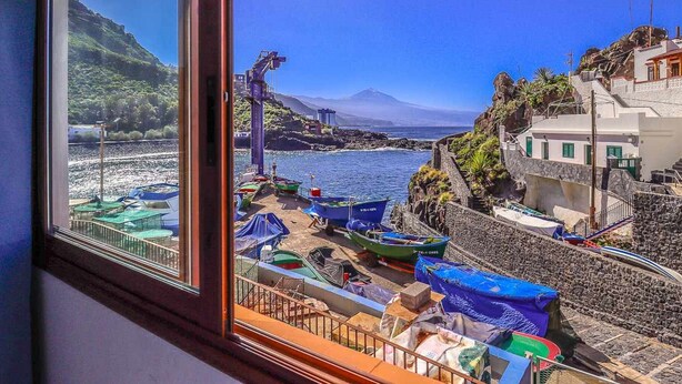 Une vue sur la côte, avec des bateaux, une montagne et des bâtiments.