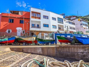 A coastal area with boats docked, a building with balconies, and a clear sky. - Renovated 2-bedroom apartment in Pris (El Pris)