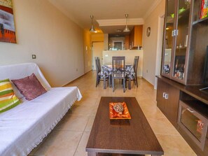 Un salon comprenant un canapé, une table basse et un coin repas avec des chaises et une table.