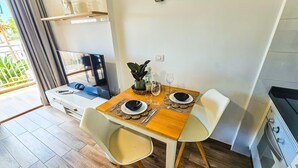 Una cucina moderna con zona pranzo, pavimento in legno e televisore.