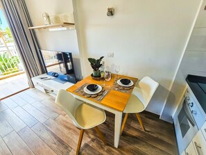 A modern kitchen with a dining area, wooden flooring, and a TV. - Bright apartment with sea view - 2 guests (Costa Adeje)