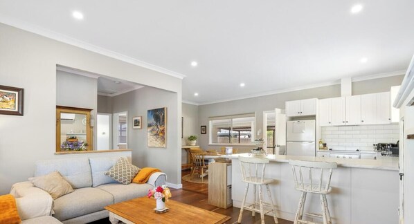 A modern apartment with a living room, kitchen, and dining area. - The Art Lovers Cottage in Mandurah 1BR (Dudley Park)