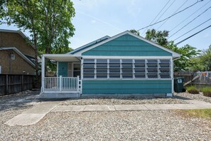 A small, single-story building with a porch and a garage door.