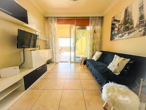 A living room with a TV, sofa, and a dog. - Apartment in Poris de Abona with private terrace and parking (Porís de Abona)