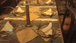 Mesa servida para comer con velas, platos y copas.