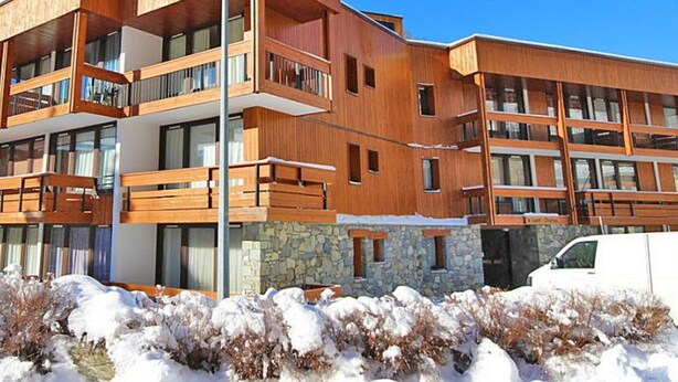 A multi-story building with wooden balconies and large windows, surrounded by snow. - Bright studio for 2 in Val d'Isère (Val-d'Isère)