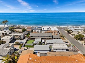 Eine Wohngegend an der Küste mit Häusern, einer Straße und einem Strand im Hintergrund.