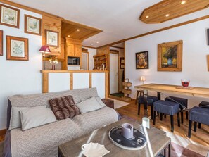 Ein gemütliches Wohnzimmer mit einer Couch, einem Couchtisch und einem Essbereich mit Stühlen.