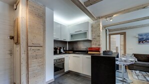 Une cuisine moderne avec des meubles en bois, un îlot central et un mur d’accent en pierre.