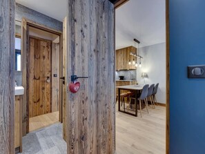 Eine moderne Küche mit Holzschränken, einem Essbereich mit Tisch und Stühlen sowie einer blauen Akzentwand.