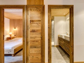 Ein Zimmer mit einem Holzbett, einem Nachttisch mit Lampe und einem Holzschrank.