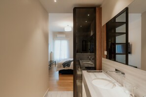 Ein modernes Badezimmer mit einem großen Spiegel, einer Badewanne und einer separaten Duschkabine.