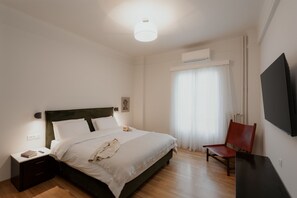 A bedroom with a bed, bedside table, chair, and a TV. - Luxury 3BR & 3 Bathrooms Apt | Metro | By Museum (Athens)