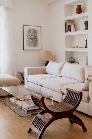 A living room with a sofa, a glass coffee table, and a wooden bench. - Luxury 3BR & 3 Bathrooms Apt | Metro | By Museum (Athens)