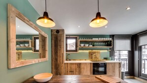 Una cuina moderna amb armaris de fusta, una illa central i il·luminació penjant.