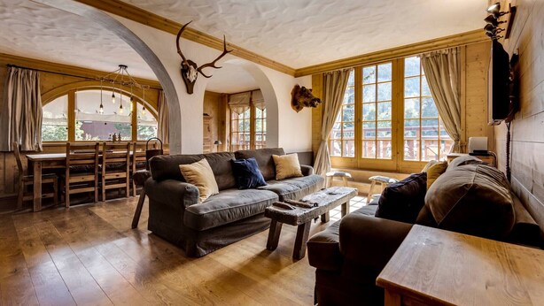 Un intérieur rustique avec une table à manger en bois, un canapé et une table basse.