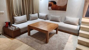 Ein modernes Wohnzimmer mit einer Couch, einem Couchtisch und einem Gemälde an der Wand.