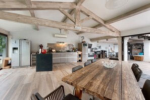 A spacious kitchen with a large island, wooden beams, and modern appliances. - Holiday Home "Bastide Neuve en Provence" with Private Pool, Terrace & Wi-Fi (Caumont-sur-Durance)
