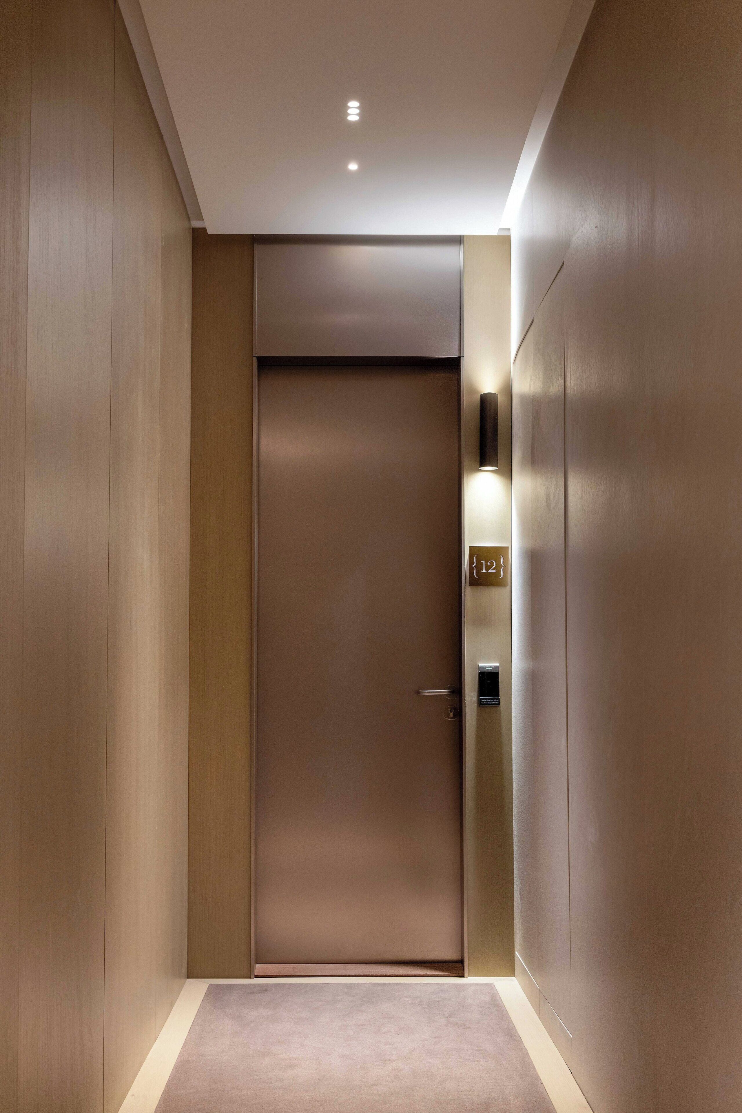 Ein moderner, minimalistisch gestalteter Aufzug mit digitaler Anzeige der Etage und einer hellen, glatten Wand.