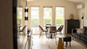 Un'ampia zona giorno con tavolo da pranzo, sedie, divano e televisione.
