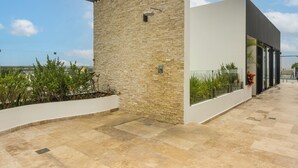 Un edificio moderno con fachada de piedra, techo plano y entrada de vidrio.