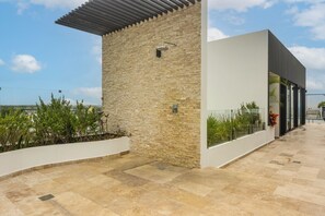 A modern building with a stone facade, a flat roof, and a glass entrance. - Walk to Beach & 5th Ave! Chic Studio w/ Patio (Playa del Carmen)